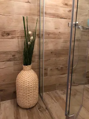 a vase with flowers in it next to a shower at Vračar Elegance Apartment in Belgrade