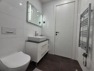 a white bathroom with a toilet and a sink at A Blok Modern Apartment in Belgrade