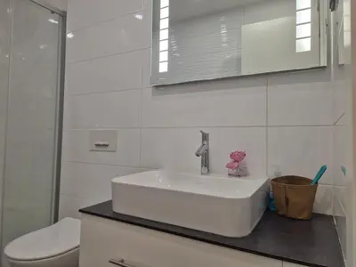 a white bathroom with a sink and a toilet at A Blok Modern Apartment in Belgrade