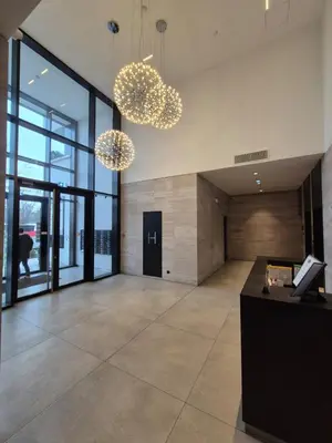 an office lobby with two chandeliers and a desk at A Blok Modern Apartment in Belgrade