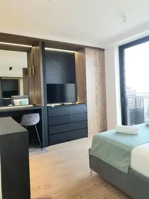 a bedroom with a bed and a desk and a television at Beograd na vodi - Belgrade Waterfront BW apartment in Belgrade