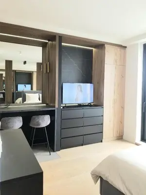 a bedroom with a desk with a television and a bed at Beograd na vodi - Belgrade Waterfront BW apartment in Belgrade