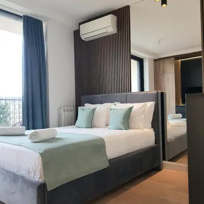 a bedroom with a large bed with blue and white pillows at Beograd na vodi - Belgrade Waterfront BW apartment in Belgrade