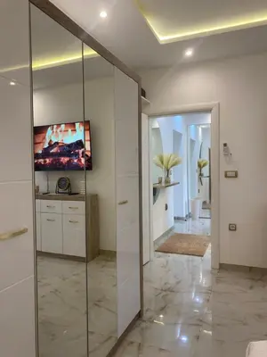 a bathroom with a glass shower and a television at Beige Harmony in Smederevo