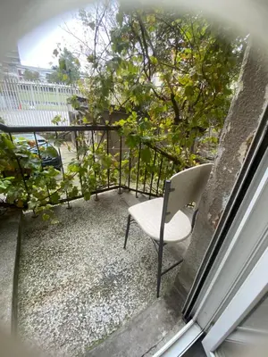 a chair sitting on a balcony looking out a window at Beige Harmony in Smederevo