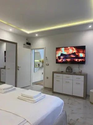 a bedroom with two beds and a flat screen tv on the wall at Beige Harmony in Smederevo