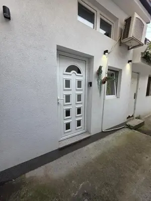 a white door on the side of a white house at Radojkovic Apartman in Belgrade