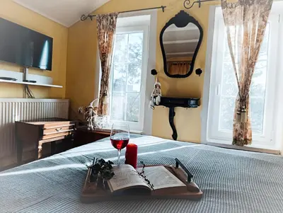 a tray with a book and a glass of wine on a bed at Kings Hill - Family Retreat in Sremski Karlovci
