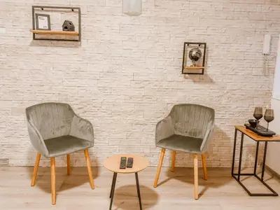 two chairs and a table in front of a brick wall at Central Spot Belgrade - ART residence in Belgrade