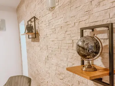 a brick wall with a mirror and a globe on a shelf at Central Spot Belgrade - ART residence in Belgrade