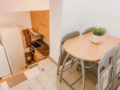 a small kitchen with a wooden table and chairs at Central Spot Belgrade - ART residence in Belgrade