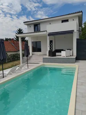 a villa with a swimming pool in front of a house at Villa Kally Fruska Gora in Velika Remeta