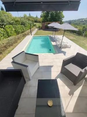 a swimming pool with two chairs and an umbrella at Villa Kally Fruska Gora in Velika Remeta