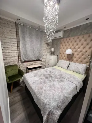 a bedroom with a large bed and a chandelier at Apartman M&A in Inđija