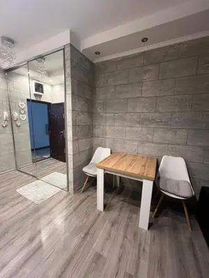 a dining room with a wooden table and two chairs at Apartman M&A in Inđija