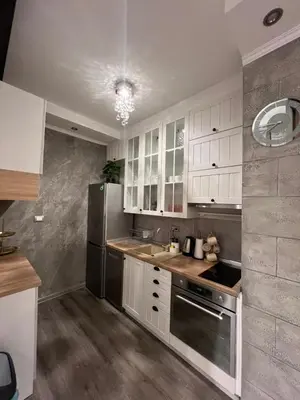 a kitchen with white cabinets and a stainless steel refrigerator at Apartman M&A in Inđija