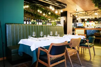a table in a restaurant with white tables and chairs at Boutique Hotel Aviator in Belgrade