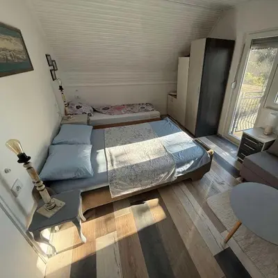 a small bedroom with a bed and a couch at Pokito House on the Hill in Sremski Karlovci