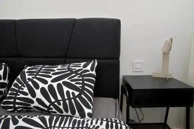 a bed with a black and white pillow next to a desk at Belgrade Waterfront Heaven! in Belgrade