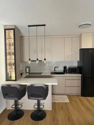 a kitchen with a white counter and two bar stools at Petra in Stara Pazova