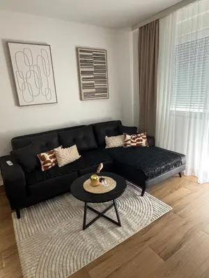 a living room with a black couch and a table at Petra in Stara Pazova