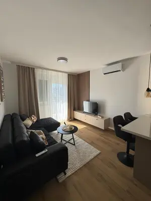 a living room with a black couch and a table at Petra in Stara Pazova