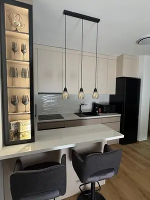 a kitchen with two chairs and a counter with lights at Petra in Stara Pazova