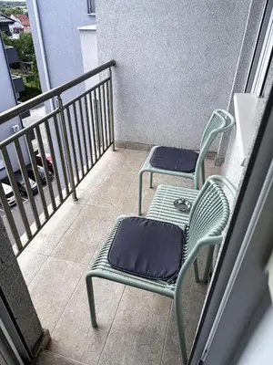 two chairs and a table on a balcony at Limpio Apartman 2 in Belgrade