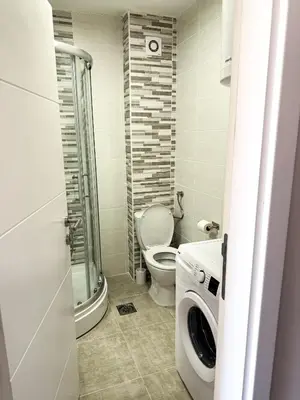 a bathroom with a toilet and a washing machine at Limpio Apartman 2 in Belgrade
