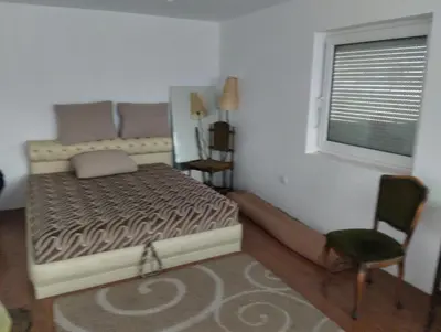 a bedroom with a bed and a window and a chair at Summer house in Belgrade in Slanci