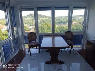 a table and two chairs in a room with windows at Summer house in Belgrade in Slanci