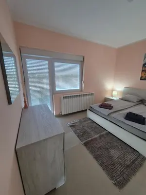 a bedroom with a bed and a large window at Rio Apartmani Ub in Ub
