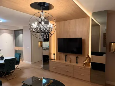 a living room with a television and a chandelier at BW Loft Apartments FREE GARAGE Fast Wi-Fi in Belgrade
