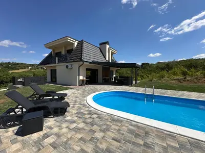 a villa with a swimming pool and a house at Vila Remeta in Velika Remeta