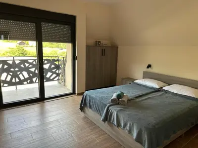 a bedroom with a bed with a teddy bear on it at Vila Remeta in Velika Remeta