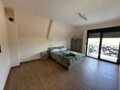a bedroom with a bed and a large window at Vila Remeta in Velika Remeta