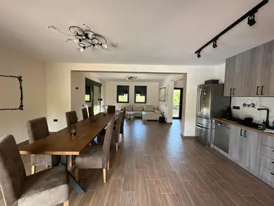 a kitchen and dining room with a table and chairs at Vila Remeta in Velika Remeta