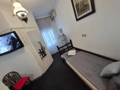a small room with a bed and a tv in it at Authentic Belgrade Centre Hostel - Only Private Rooms in Belgrade
