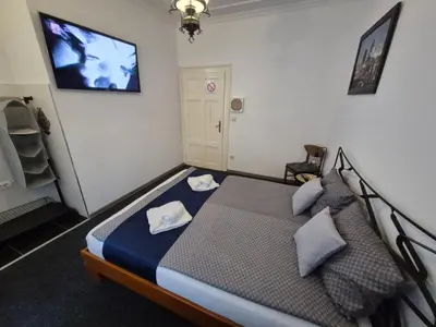 a bedroom with a bed with a tv on the wall at Authentic Belgrade Centre Hostel - Only Private Rooms in Belgrade