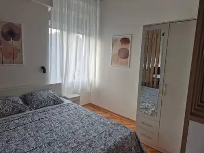 a bedroom with a bed and a dresser at URBAN Suites in Belgrade