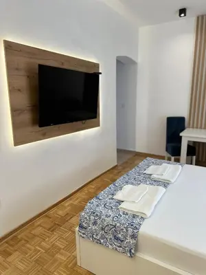 a room with a bed with a tv on a wall at URBAN Suites in Belgrade