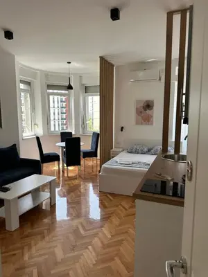 a living room with a bed and a dining room at URBAN Suites in Belgrade