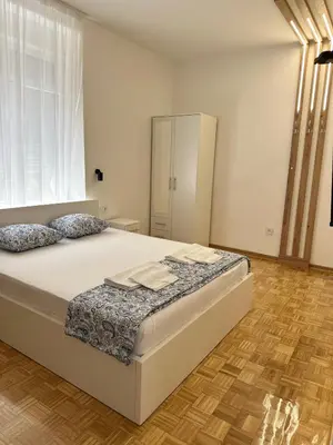 a bedroom with a large white bed with two pillows at URBAN Suites in Belgrade