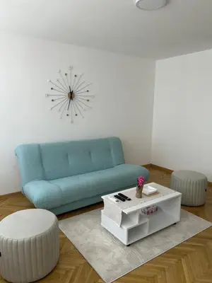 a living room with a blue couch and a coffee table at MT Apartman in Belgrade