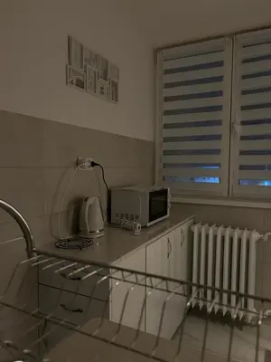 a kitchen with a counter with a microwave and a window at MT Apartman in Belgrade