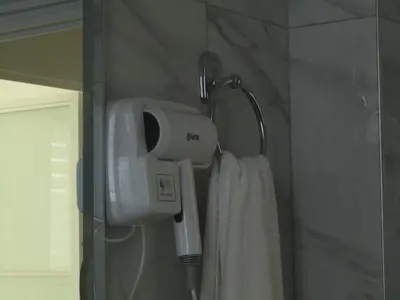 a hair dryer hanging on a wall in a bathroom at MT Apartman in Belgrade