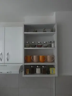 a kitchen cabinet filled with lots of pots and pans at MT Apartman in Belgrade