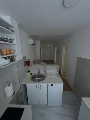 a small white kitchen with a sink in it at MT Apartman in Belgrade