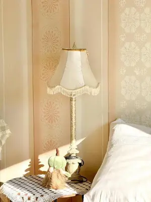 a lamp sitting on a table next to a bed at Kuća za odmor ,, Bundevica,,