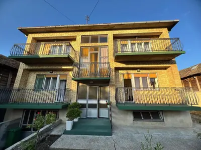 a yellow brick building with balconies on it at Kuća za odmor ,, Bundevica,,
